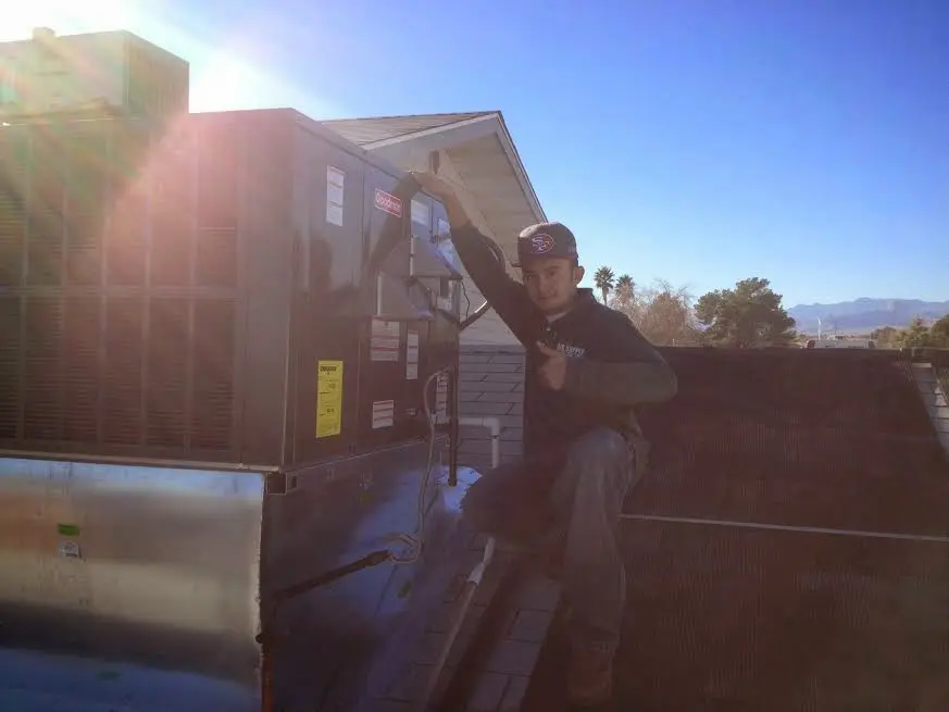 HVAC technician performing Boiler Repair on a rooftop unit in Millcreek